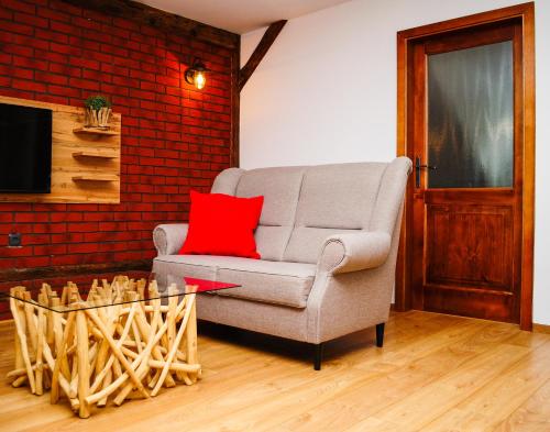 a living room with a chair and a red pillow at Apartmány RUMPA-DRINKS in Ostrava