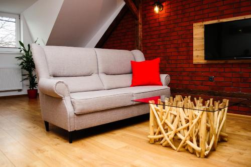 a living room with a couch and a red brick wall at Apartmány RUMPA-DRINKS in Ostrava