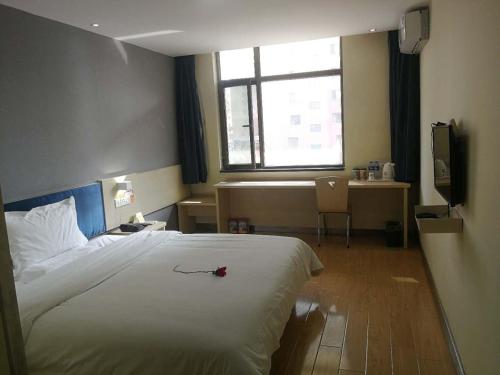 a hotel room with a large bed and a window at 7Days Inn Lintao city Gold street in Taoyang