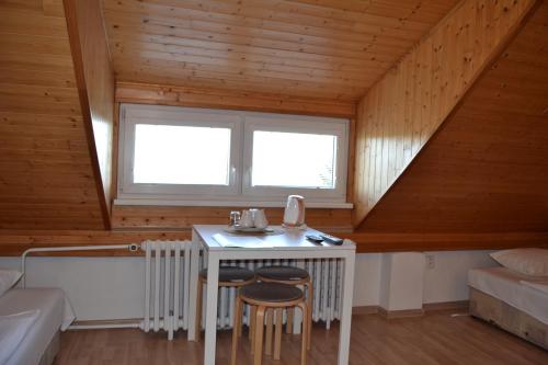 a room with a table with two chairs and a window at Pension Nika in Prague