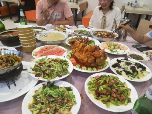una mesa con platos de comida. en 7Days Inn Dezhou Qihe Coach College, en Dezhou