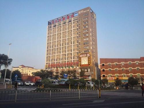 een hoog gebouw met een klok ervoor bij 7Days Inn Shenzhen Shiyan in Longwancun
