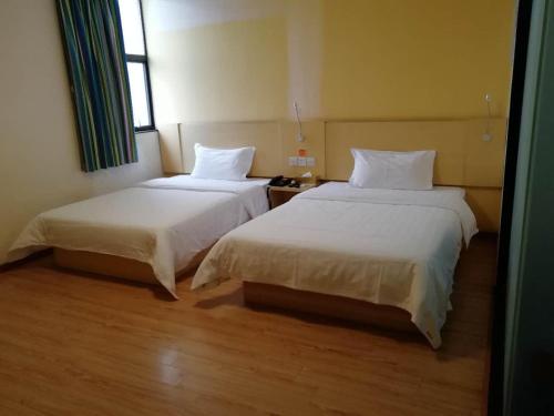 2 bedden in een hotelkamer met 2 bedden van 6 x 7 cm bij 7Days Inn Shenzhen Shiyan in Longwancun