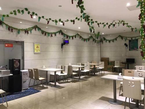 a dining room with tables and chairs and green garland at 7Days Inn Yongzhou Lengshuitan Shun De mol of BBK Plaza in Yongzhou