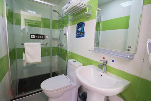 uma casa de banho verde e branca com um WC e um lavatório em 7Days Inn ChengDu RenShou Shuyuan Road Haochi Street em Meishan