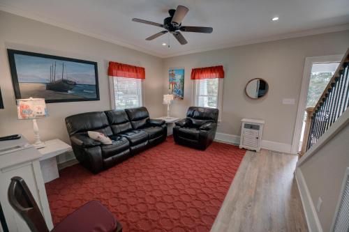 a living room with two chairs and a ceiling fan at Outer Banks Motel - Village Accommodations in Buxton