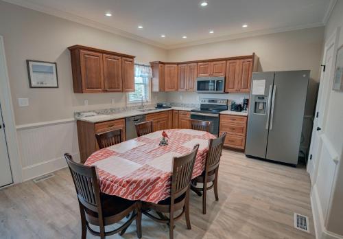 a kitchen with a table with chairs and a refrigerator at Outer Banks Motel - Village Accommodations in Buxton