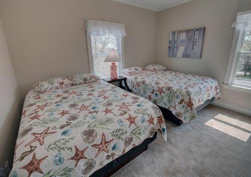 a bedroom with two beds and a window at Outer Banks Motel - Village Accommodations in Buxton