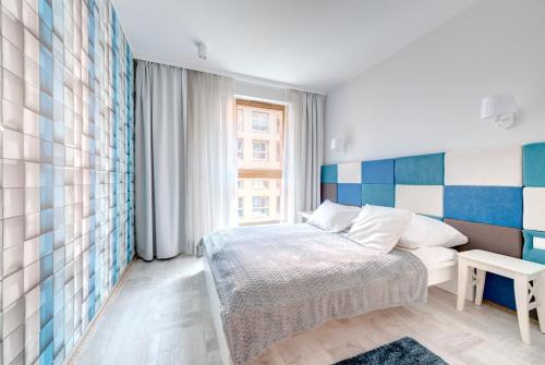um pequeno quarto com uma cama e uma janela em 3 City Apartments - Admiralski em Gdansk