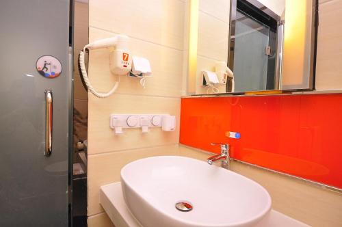 y baño con lavabo blanco y espejo. en 7Days Premium Ji`nan Luokou Clothing City Wuying Hill North Road en Jinan