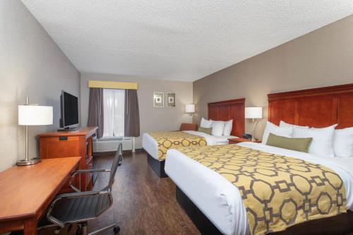 Habitación de hotel con 2 camas y escritorio en Baymont by Wyndham Greenville OH, en Greenville