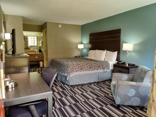 um quarto de hotel com uma cama e uma cadeira em Days Inn by Wyndham Southaven MS em Southaven