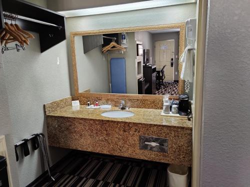 a bathroom with a sink and a large mirror at Days Inn by Wyndham Southaven MS in Southaven