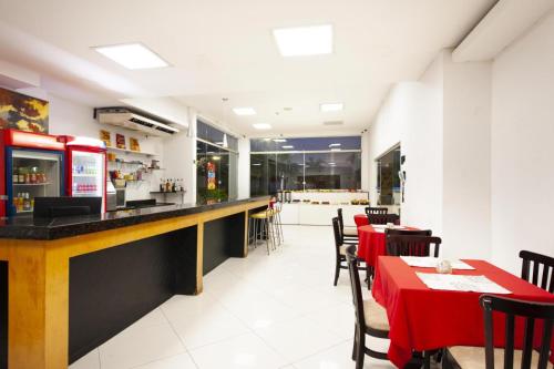 a restaurant with a bar and tables and chairs at GOLD MARTAN HOTEL in Belém