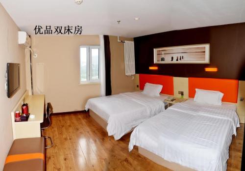 a hotel room with two beds and a tv at 7Days Premium Panjin Oilfield Bus Terminal in Panjin