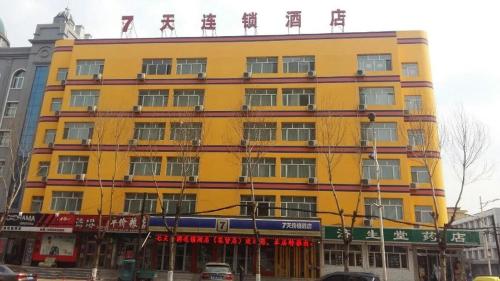 um edifício amarelo com escrita chinesa em cima em 7Days Inn Jixian County Road em Shuangyashan