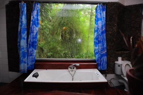 uma banheira na casa de banho com uma janela em Boulder Garden em Kalawana