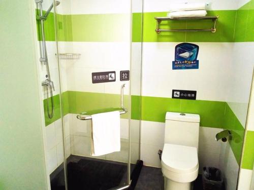 - une salle de bains verte et blanche avec toilettes et douche dans l'établissement 7Days Inn Weinan Jiefang Road railway station, à Weinan
