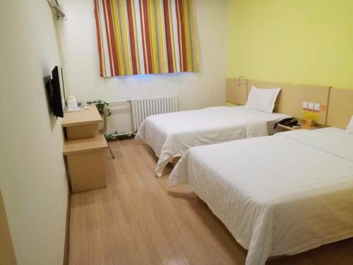 7Days Inn Tianjin Zhongshan Road North Station tesisinde bir odada yatak veya yataklar