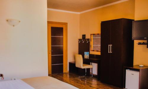 a bedroom with a bed and a desk with a chair at Hotel Nais Beach in Durrës