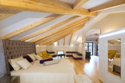 a living room with a large white couch and wooden ceilings at Palazzo Banicevic Luxury Rooms in Kotor