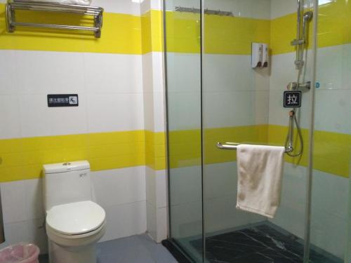 a bathroom with a toilet and a glass shower at 7Days Inn Kangding passenger terminal station in Garze