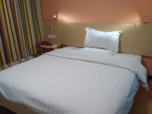 a large white bed in a hotel room at 7Days Inn Kangding passenger terminal station in Garze