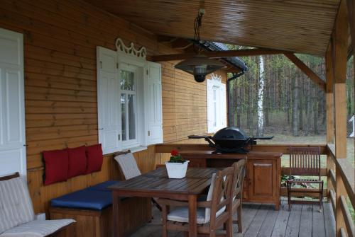 a screened in porch with a table and a grill at Wakacyjny Dom w Sakach in Kleszczele