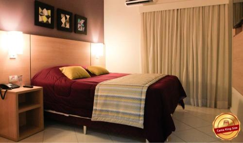 a hotel room with a bed and a night stand at The World Indaiatuba in Indaiatuba