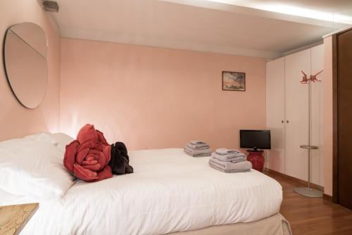 a bedroom with a white bed with a red stuffed animal on it at Casa Flavia ai Morosini - Luxury apartment with Canal View in Venice