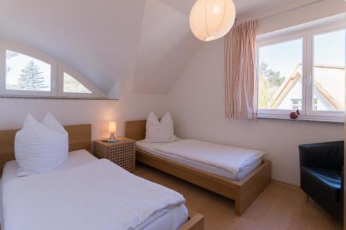two beds in a room with two windows at STRANDHAUS 43 in Dierhagen