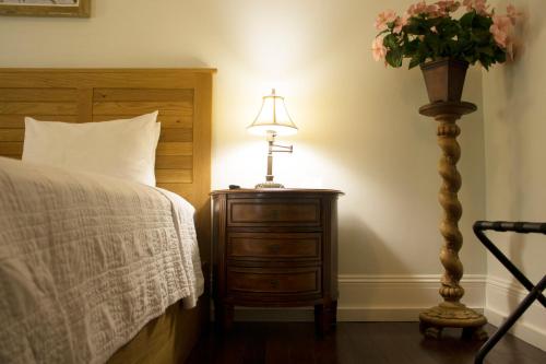 a bedroom with a bed and a table with a lamp at Duval House in Key West