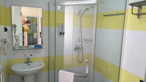 a bathroom with a sink and a glass shower at 7Days Inn Yiyang victory road in Shangrao