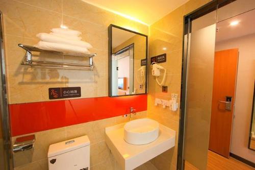 a bathroom with a sink and a mirror at 7Days Premium Jingjiang Fuhai New World Bus Station in Jingjiang