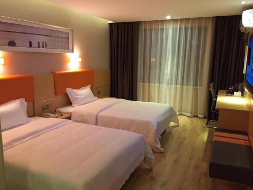 una camera d'albergo con due letti e una televisione di 7Days Premium Wangcheng Walking Street a Changsha