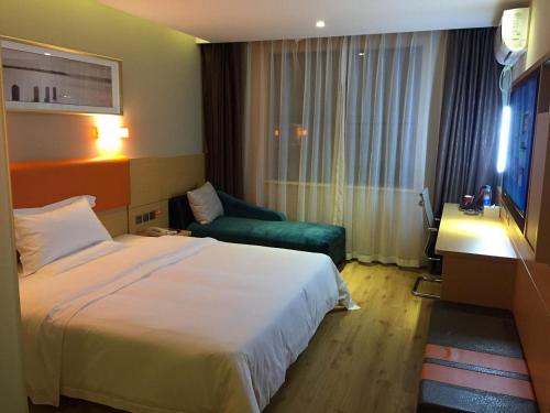 ein Hotelzimmer mit einem Bett und einem Sofa in der Unterkunft 7Days Premium Wangcheng Walking Street in Changsha