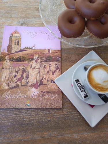 a cup of coffee and donuts on a table at Hospedium Hotel El Nido de Alcudia Suites in Almodóvar del Campo