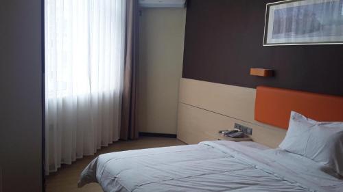 um quarto com uma cama e uma grande janela em 7Days Premium Ziyang Anyue Ningdu Avenue em Yueyang