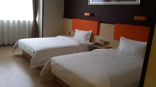 um quarto de hotel com duas camas e uma janela em 7Days Premium Ziyang Anyue Ningdu Avenue em Yueyang