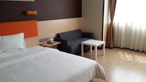 um quarto com uma cama e um sofá em 7Days Premium Ziyang Anyue Ningdu Avenue em Yueyang