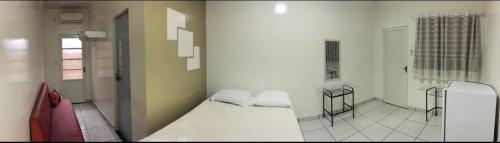 - une chambre avec un lit blanc et 2 oreillers dans l'établissement HOTEL ALAMEDA, à Várzea Grande