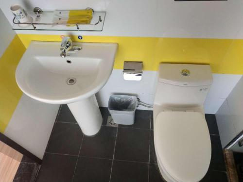 La salle de bains est pourvue de toilettes blanches et d'un lavabo. dans l'établissement 7Days Inn Tongliao Civil Aviation Road, à Tongliao