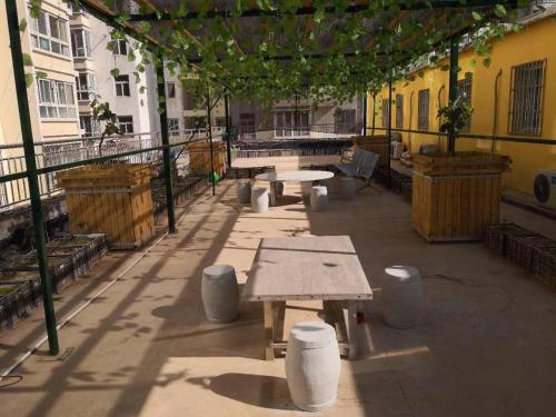 a patio with tables and benches on a building at 7Days Inn Yanan East Street Bus Station in Yan'an