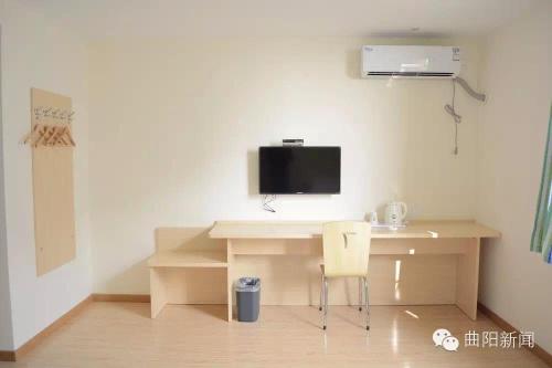 Cette chambre dispose d'un bureau, d'une télévision et d'une chaise. dans l'établissement 7Days Inn Baoding Quyang Taihang Road Bus Terminal, à Quyang