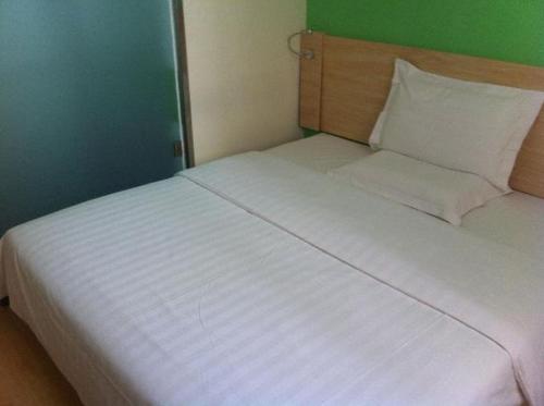 1 cama blanca grande en una habitación con una pared verde en 7Days Inn Chifeng Linxi Haichuan Square Branch en Linxi