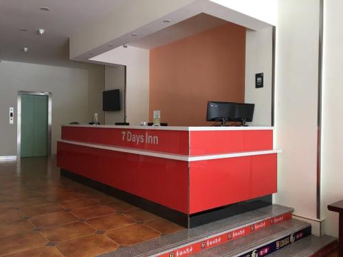 a red lobby with a tuesday inn counter in a building at 7Days Inn Chifeng Linxi Haichuan Square Branch in Linxi