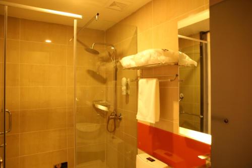 bagno con doccia e porta in vetro di 7Days Premium Shihezi Recreation Plaza Merino Museum a Shihezi