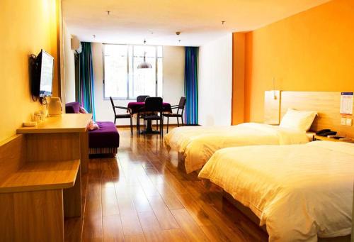 pokój hotelowy z 2 łóżkami i stołem w obiekcie 7Days Inn Chongqing Yunyang passenger terminal station w mieście Shuangjiang