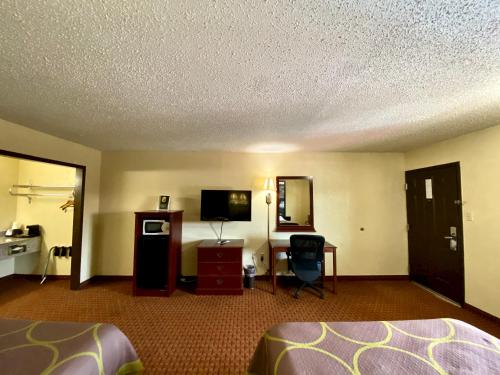 Una televisión o centro de entretenimiento en Super 8 by Wyndham Shawnee