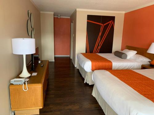 a hotel room with two beds and a lamp at Howard Johnson by Wyndham Niagara Falls in Niagara Falls
